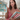 A woman in a red and white gingham top holds up a workbook titled 'Dimensions Math Textbook 3A' while holding a stack of similar math workbooks in her other hand, set against a softly blurred indoor background.
