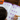 Child working on a math worksheet with a pencil on a wooden table, next to a textbook.